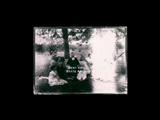 Taylor family group at "Holmefield." A man (Jackson Taylor), women, and several children seated under a tree. Fence in the background. Part of the image is washed out.