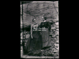 Two women (Minnie Taylor Raven and May) standing in front of rocks.