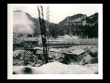 East abutment and guide wall site during the hydroelectric power construction on the New River. Completed concrete mixer shown in center, cement house at right, and sand and gravel bins in foreground. Excavation for guide walls shown at extreme right. New-Kanawha Power Company, Hawks Nest - Gauley Junction Development No. 140.