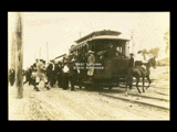 Car No. 29 at South Side Park in Fairmont with people onboard. Woman on horse is riding across tracks.
