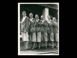 Group of six men wearing identified outfits of striped jackets, knickers, and striped socks. Possibly a band in 1925, with Walter Schneider second from right.