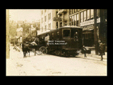Fairmont and Clarksburg Traction Company freight car on Jefferson Street in front of Manley Hotel. Horse drawn wagon alongside.