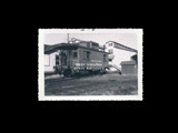 Meadow River Lumber Company caboose No. 2 beside buildings. From small red photo album.