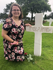 Emily Rinick at the Normandy American Cemetery beside the cross of the soldier she researched. Courtesy Kizmet Chandler