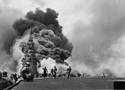 The scene on <i>Bunker Hill</i>'s flight deck looking aft, while her crew fights fires caused by the two kamikaze attacks off Okinawa on 11 May 1945. This iconic image from World War II appears on the RCA Victor recording of the orchestral suite <i>Victory at Sea</i> in the early 1950s. U.S. Navy Photograph 80-G-323712, National Archives and Records Administration, Still Pictures Division, College Park, MD