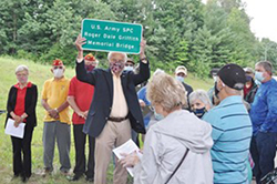 Delegate Bill Hartman holds up a miniature version of the new sign placed on the overpass spanning Laurel Mountain Road. Courtesy of Brad Johnson, <i>Elkins Inter-Mountain</i>