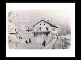 Jackson Taylor house and family outside in Nuttalburg. Two-story house with outbuildings and fence. People include Jackson and Martha Taylor, John and Minnie. <p> Identification note: Jackson and Martha Taylor and John and Minnie standing in the yard. The cook and nurse with the baby in rear. All nine Taylors were born in this house. It became the club house or hotel in Nuttalburg.