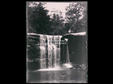 Woman (Minnie Taylor) and unidentified man sitting on rock beside Glade Creek falls near J. Eddy.