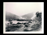 Buildings of the Electro Metallurgical Company Kanawha works at Glen Ferris with the Kanawha River and tree covered hills behind.