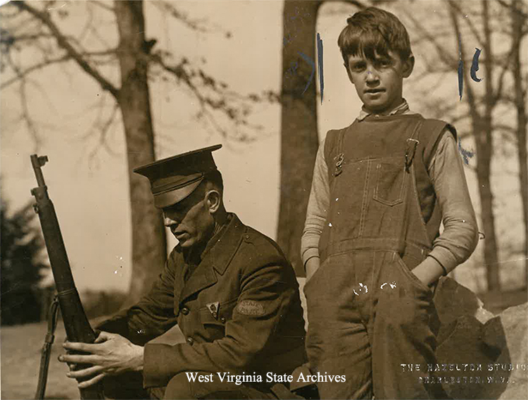 Johnny Evans, 10, who was fired upon during the WV coal strikes, with a state policeman, ca. 1920. David Doss Collection, West Virginia State Archives