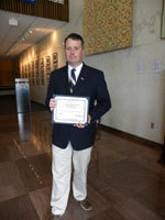 Bryan Ward holding grant award certificate