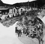 Top: Federal troops from Fort Thomas setting up their tents
in the yards of union homes at Sharples.
Bottom: a guard on duty at another of the mining towns. The men in the background
have just been disarmed. Jeffrey was used as a concentration point for the union miners.
seven hundred armed men were in the town
when troops arrived. Huntington, September