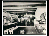 Interior of the store at Caretta. Boy in knee pants and other, blurry people in the back of the store.
