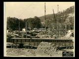 Girders and blocks for Building 2 (East Wing) during construction of the Cass Gilbert WV State Capitol building. A railroad car is in the foreground.