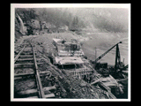 Tunnel intake during the hydroelectric power construction on the New River. View looking downstream showing backfill being placed over completed tunnel intake. Front of intake shown in center and upstream retaining wall at left. New-Kanawha Power Company, Hawks Nest - Gauley Junction Development No. 354.