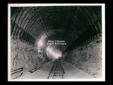 View into tunnel during the hydroelectric power construction on the New River. View shows completed invert section of tunnel lining. Wooden plugs along edges of invert are to prevent dirt from falling into nuts which are cast in the concrete. The overlapping portion of the steel formwork will be bolted to these nuts when the tunnel lining is being placed. Camera at Station 13 + 40 looking downstream. New-Kanawha Power Company, Hawks Nest - Gauley Junction Development No. 361.