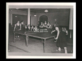 Two girls (Demain Donley and Patricia Hannon) playing ping pong while other girls watch at Mount de Chantal Visitation Academy in Wheeling. Note: Used in 1951 yearbook.