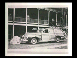 Sister sitting at the wheel of an automobile (station wagon) in front of a building at Mount de Chantal Visitation Academy in Wheeling. "Mount de Chantal" written on side panel.