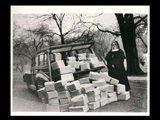 Mount de Chantal Sister standing beside packages for war effort piled at rear of automobile (station wagon) and inside.