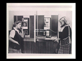 Two students (Cynthia Sambuco and Martha Witte) standing at pay telephones at Mount de Chantal Visitation Academy in Wheeling.
