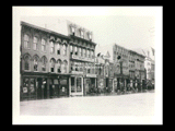 View along the 1500 block of Market Street during Wheeling flood. Signs include Werner's Cafe, Hottman's Hotel, Hottman's Restaurant, Friedrichs & Company Novelty Works, Quarter Savings Bank, People's Credit Clothing Company.