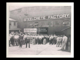 Green Cross Award of Honor ceremony at Steelcrete Factory. Crowd of men standing outside building.