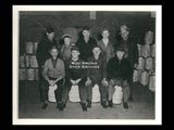 Longtime Wheeling Steel employees. Barrels. First row: Edward Braun, Henry Megale, John Penter, and Charles Massina. Second row: Harry Hickey, Bob Smith, Wally Becker, George Kline and John Quigley.