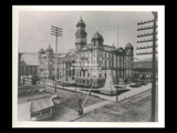 View of the Ohio County and City Government building (former state capitol) in Wheeling, with monument at corner. Wheeling and Elm Grove station at right.