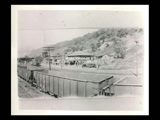 Part of panoroma of Warwood with empty railroad cars in the foreground. Wheeling Gasoline and Oil Company station, automobiles. Right cirkut.