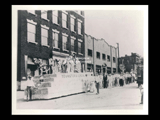 Parade along 16th Street in Wheeling with patriotic float for Teamsters Local 697. Signs include Ford Lincoln Zephur Mercury.